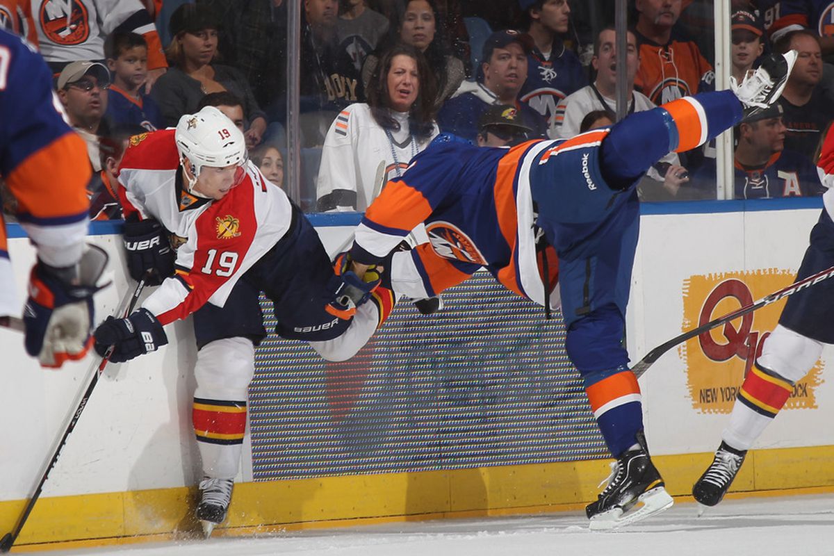 UNIONDALE, NY - OCTOBER 08: Scottie Upshall #19 of the Florida Panthers hits Blake Comeau #57 of the New York Islanders at the Nassau Veterans Memorial Coliseum on October 8, 2011 in Uniondale, New York.  (Photo by Bruce Bennett/Getty Images)
