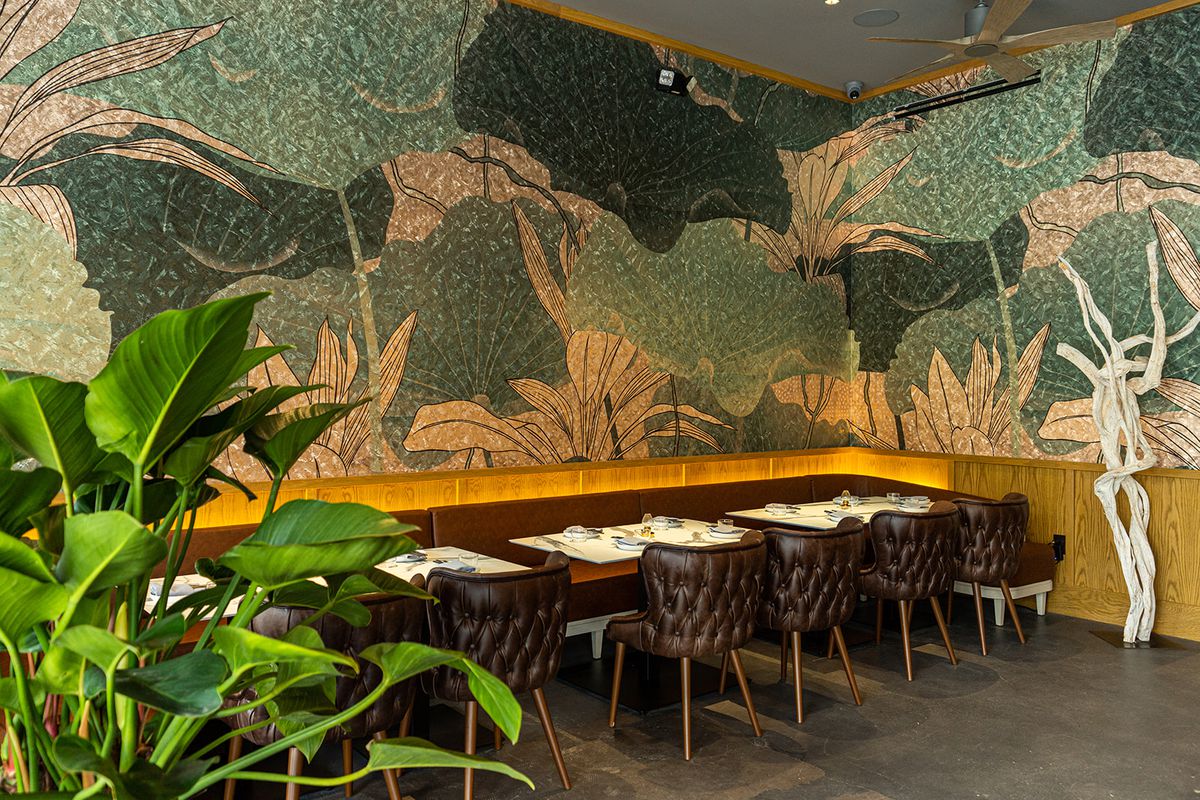A beautiful wall covered in a lotus print with dining tables.
