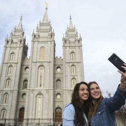 Mika Katich, of Auburn, Ala., and Chelsey Campbell, of California, take a selfie in front of the Salt Lake Temple as conferencegoers arrive at the Conference Center for the Sunday morning session of the 189th Annual General Conference of The Church of Jesus Christ of Latter-day Saints in Salt Lake City on Sunday, April 7, 2019.