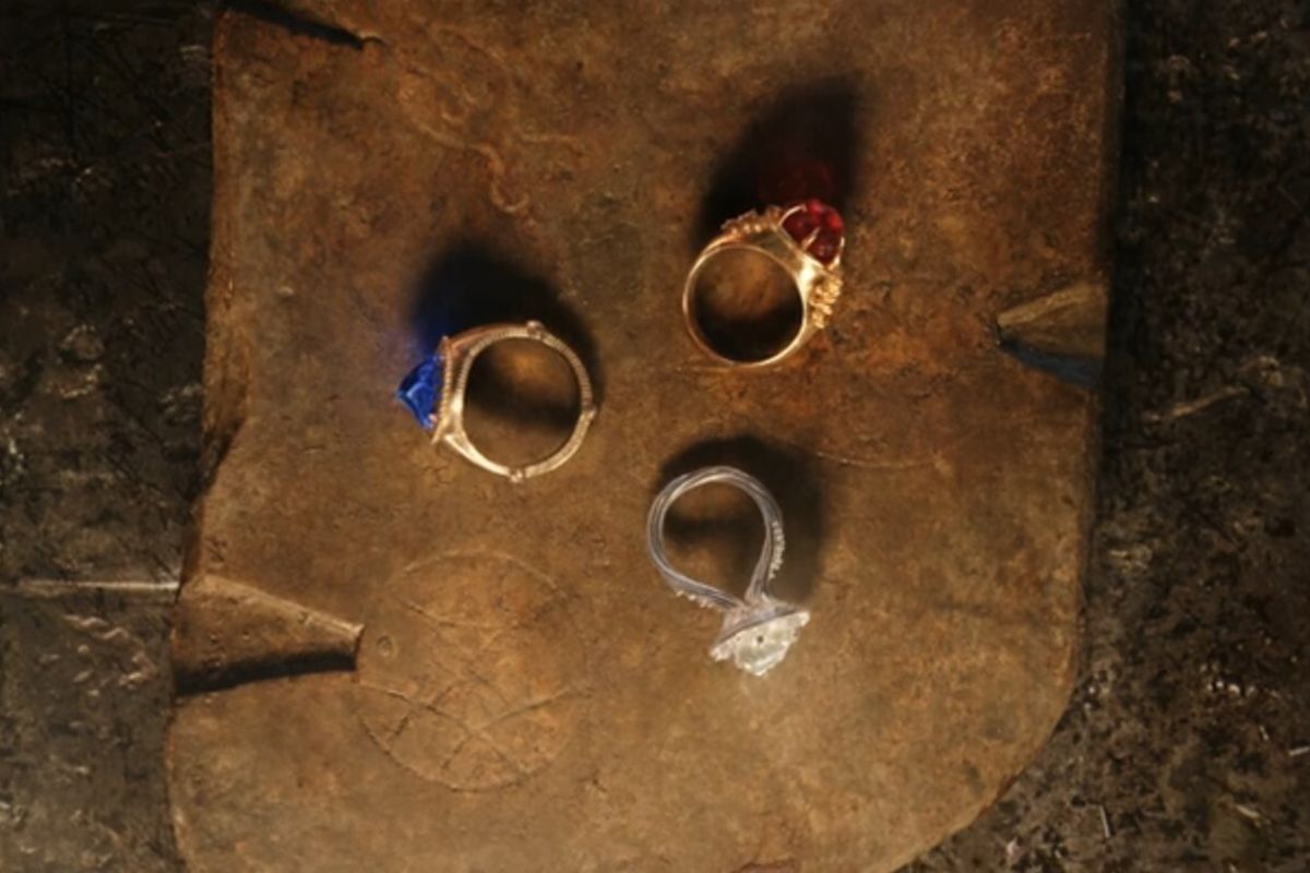Narya, Nenya, and Vilya, the three Elven Rings, seen on a stone surface in The Lord of the Rings: The Rings of Power. 