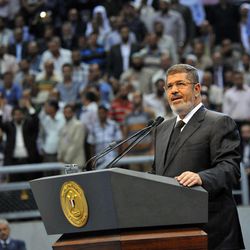 In this image released by the Egyptian Presidency, Egyptian President Mohammed Morsi addresses a rally called for by hardline Islamists loyal to the Egyptian president to show solidarity with the people of Syria, in a stadium in Cairo, Egypt, Sunday, June 15, 2013. Egypt's Islamist president announced Saturday that he was cutting off diplomatic relations with Syria and closing Damascus' embassy in Cairo, decisions made amid growing calls from hard-line Sunni clerics in Egypt and elsewhere to launch a "holy war" against Syria's embattled regime. 