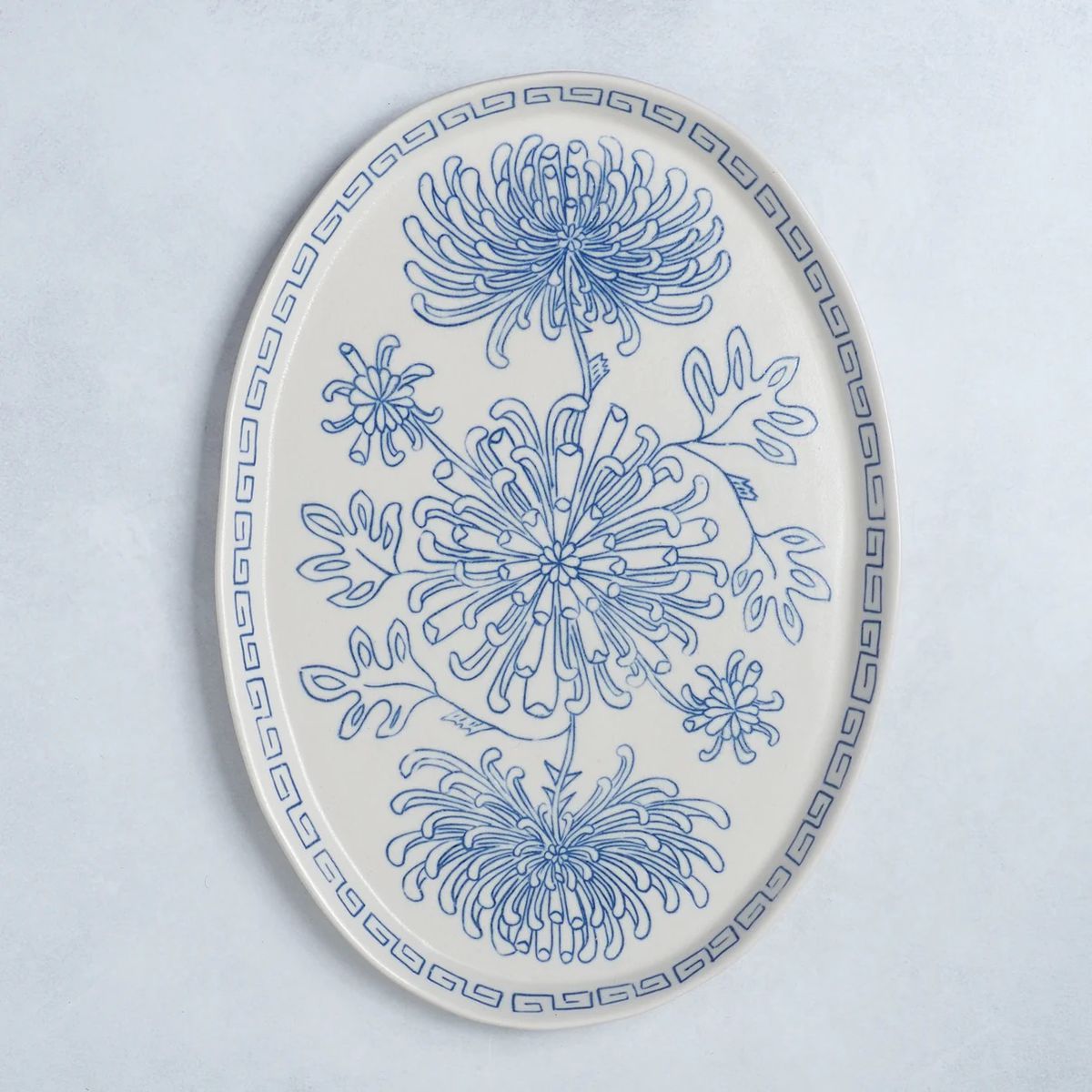 A large, oval-shaped porcelain platter with a chrysanthemum design.