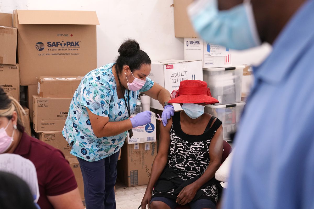 In this April 10, 2021, file photo, registered nurse Ashleigh Velasco, left, administers the Johnson &amp; Johnson COVID-19 vaccine to Rosemene Lordeus, right, at a clinic held by Healthcare Network in Immokalee, Fla. Fewer Americans are reluctant to get a COVID-19 vaccine than just a few months ago, but questions about side effects and how the shots were tested still hold some back, according to a new poll that highlights the challenges at a pivotal moment in the U.S. vaccination campaign.