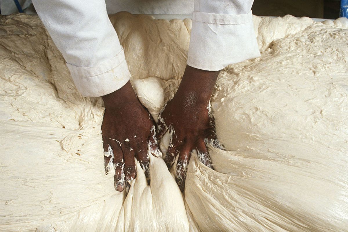 A baker kneading dough that’s to become ciabatta.