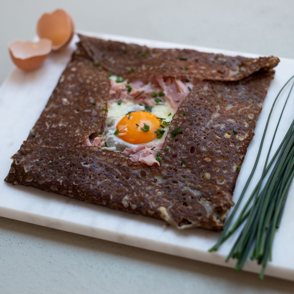 A buckwheat crepe with an egg peaking out in the center. 