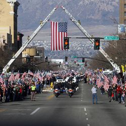 The motorcade makes it way through the huge crowds of supporters as they line up along Washington Blvd., while the casket of Ogden officer Jared Francom makes its way to the Ogden Cemetery in Ogden Wednesday, January 11, 2012. Francom and five others were injured during a routine drug raid last week.