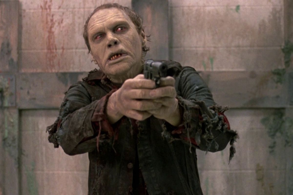 A zombie holds a gun in George Romero’s Day of the Dead.