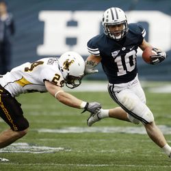 JJ Di Luigi of Brigham Young runs around the arms of Chris Prosinski of Wyoming during the first have of play at Edwards Stadium in Provo, Oct. 23, 2010. (Brian Nicholson, Deseret News Archives)