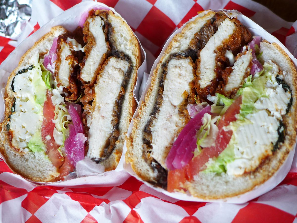A Mexican cemita sandwich loaded with fried chicken seen in cross section.