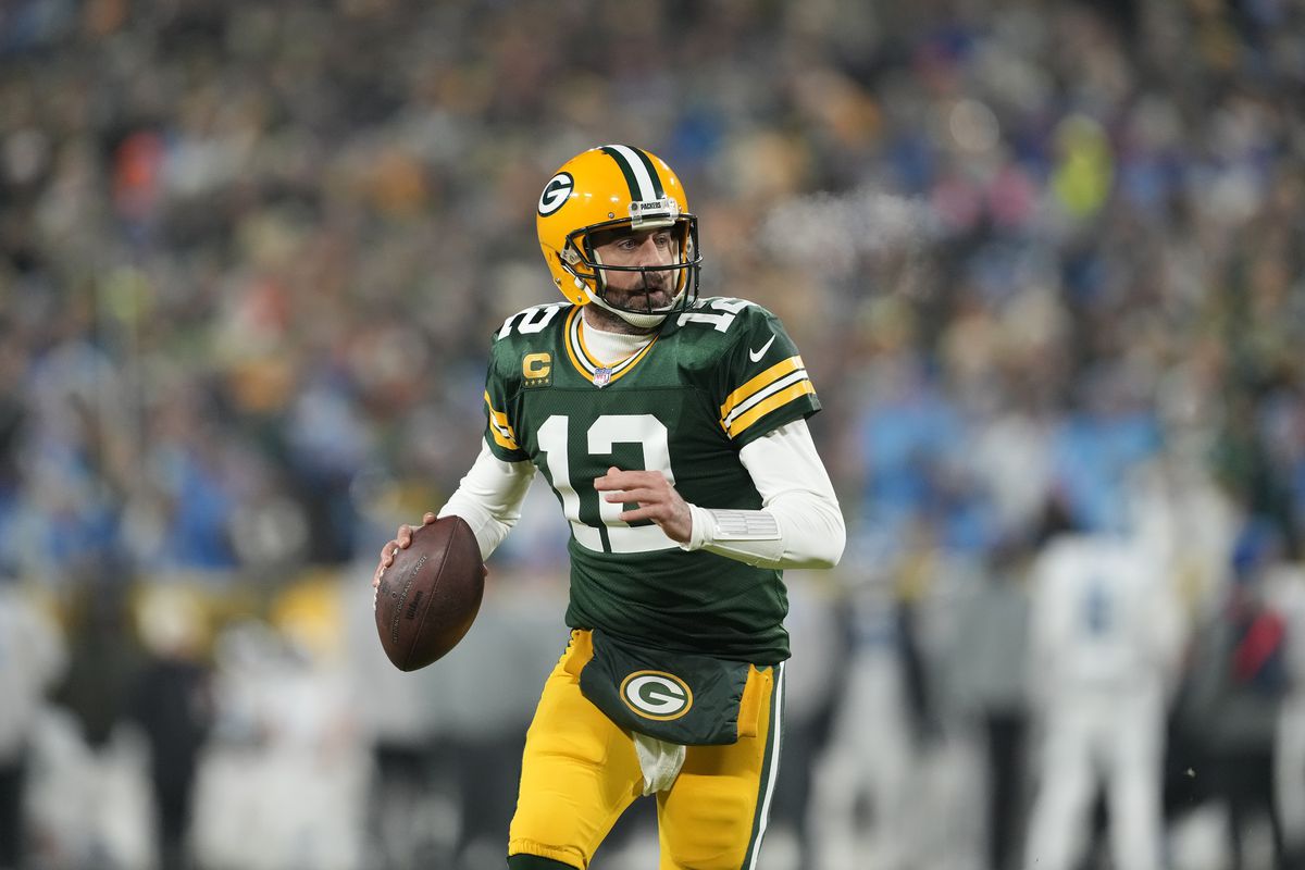 Aaron Rodgers #12 of the Green Bay Packers scrambles with the ball against the Detroit Lions in the first half at Lambeau Field on January 08, 2023 in Green Bay, Wisconsin.