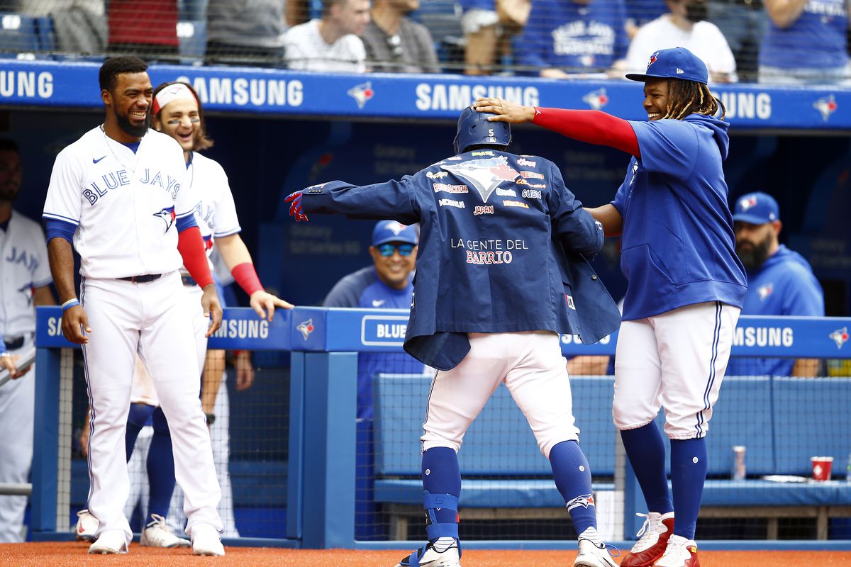 Santiago Espinal #5 of the Toronto Blue Jays receives the Blue Jays Home Run Jacket from Vladimir Guerrero Jr. #27 after hitting a home run in the fourth inning during a MLB game against the Kansas City Royals at Rogers Centre on August 01, 2021 in Toronto, Canada.