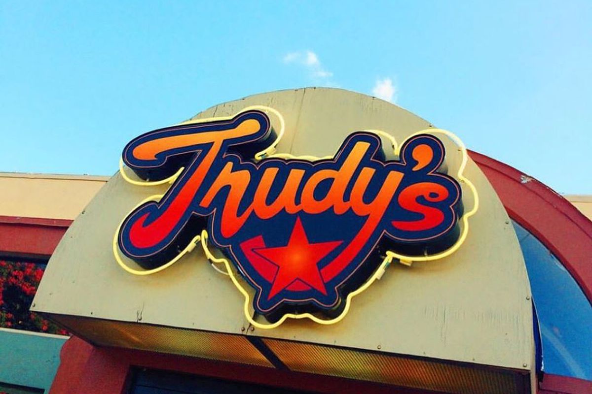 Red sign that says Trudy’s with blue sky background