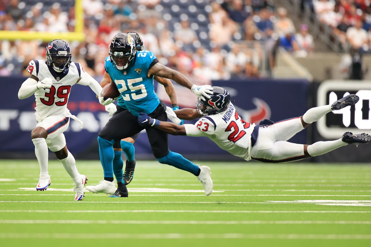 James Robinson #25 of the Jacksonville Jaguars stiff arms Eric Murray #23 of the Houston Texans during the second half at NRG Stadium on September 12, 2021 in Houston, Texas.