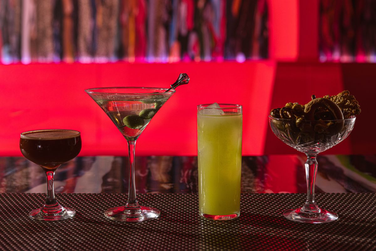 Four cocktails arrayed on a bar.
