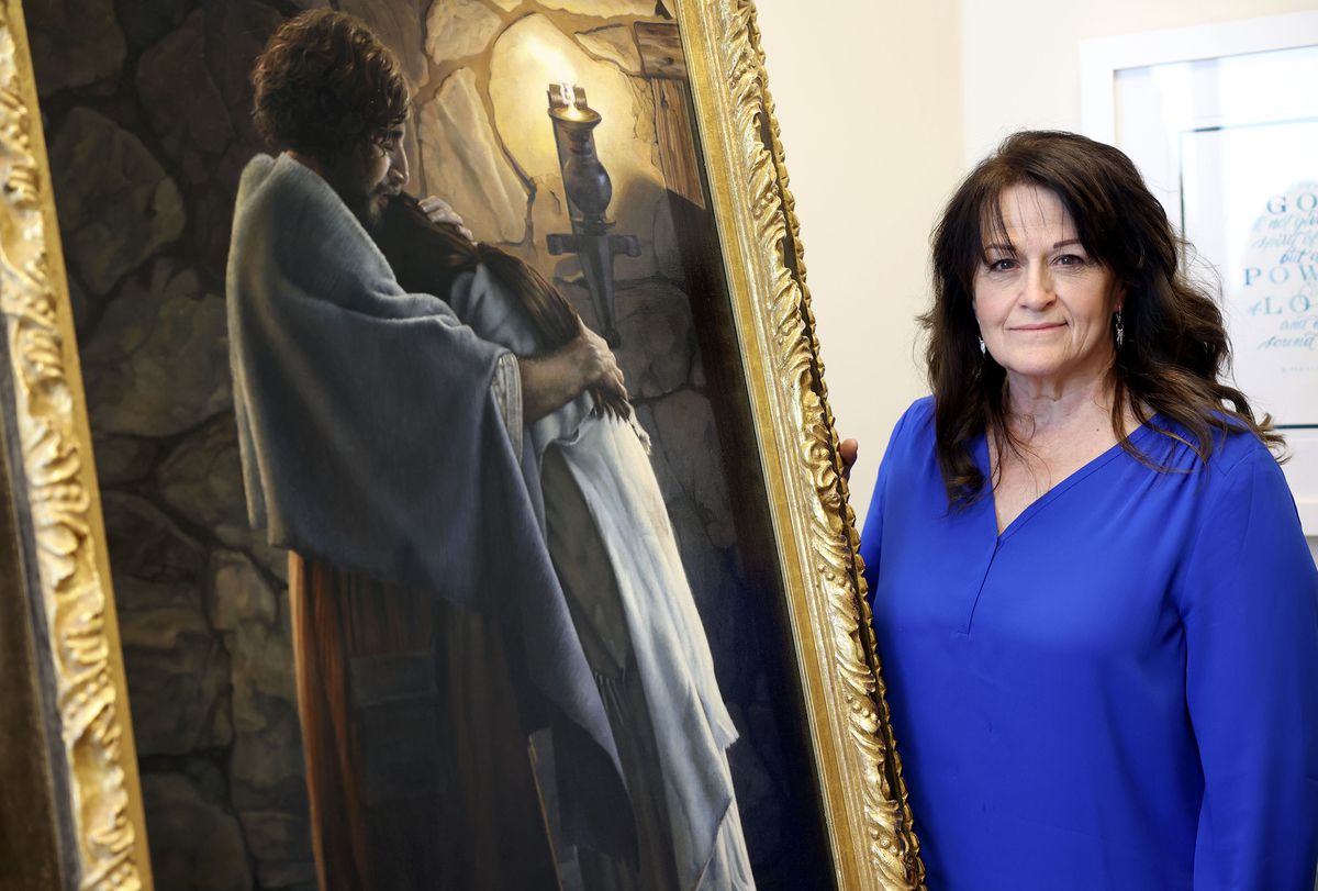 Liz Lemon Swindle poses for a portrait with her painting, “You Are Mine,” in her studio office in Provo, Utah.
