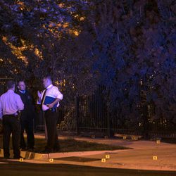 In this Aug. 8, 2017 photo, Chicago Police investigate a shooting near East 37th Street and  South Michigan Avenue, about two blocks from the Chicago Police Department headquarters. Police say several gunmen opened fire on a group of people standing on a Chicago sidewalk, killing one and wounding six others. (Ashlee Rezin/Sun Times via AP)