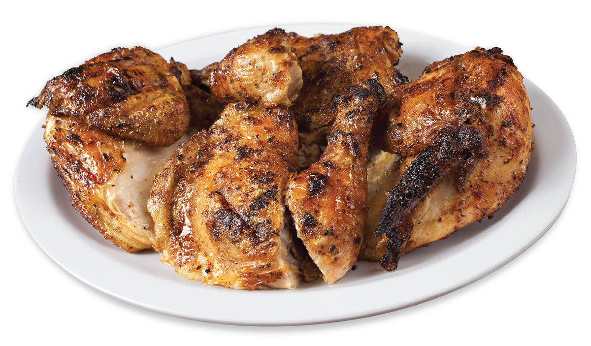 Pile of grilled chicken, served on a white plate.