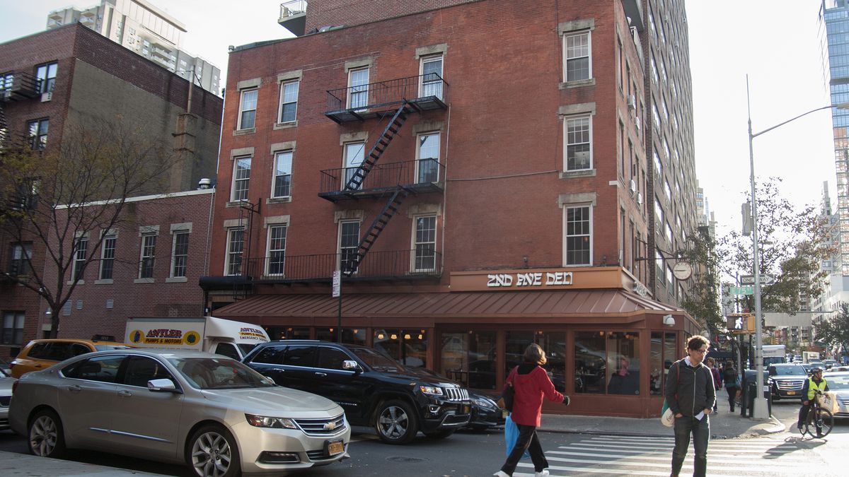 A brick building in New York City with 2nd Ave Deli on the ground floor.