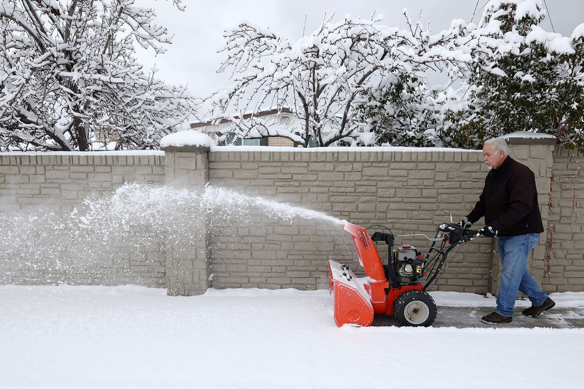Scott Walker uses his snowblower to remove snow from the sidewalks around his home in Murray as snow falls along the Wasatch Front on Friday, Dec. 10, 2021.
