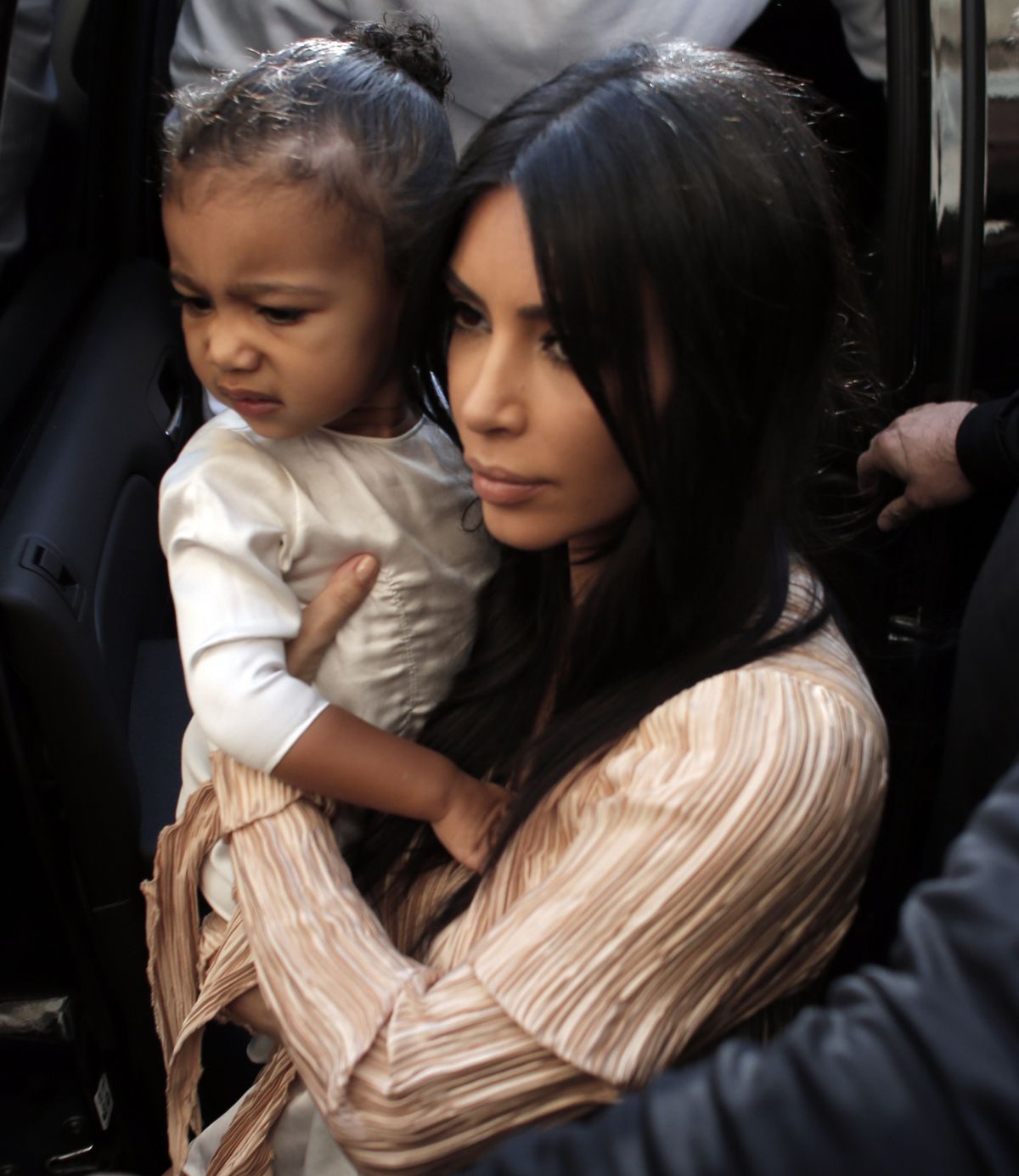 Kim Kardashian West carries her daughter North West as she and her husband rapper Kanye West (back) exit a car upon their arrival at the Armenian St. James Cathedral in Jerusalem’s Old City in 2015.