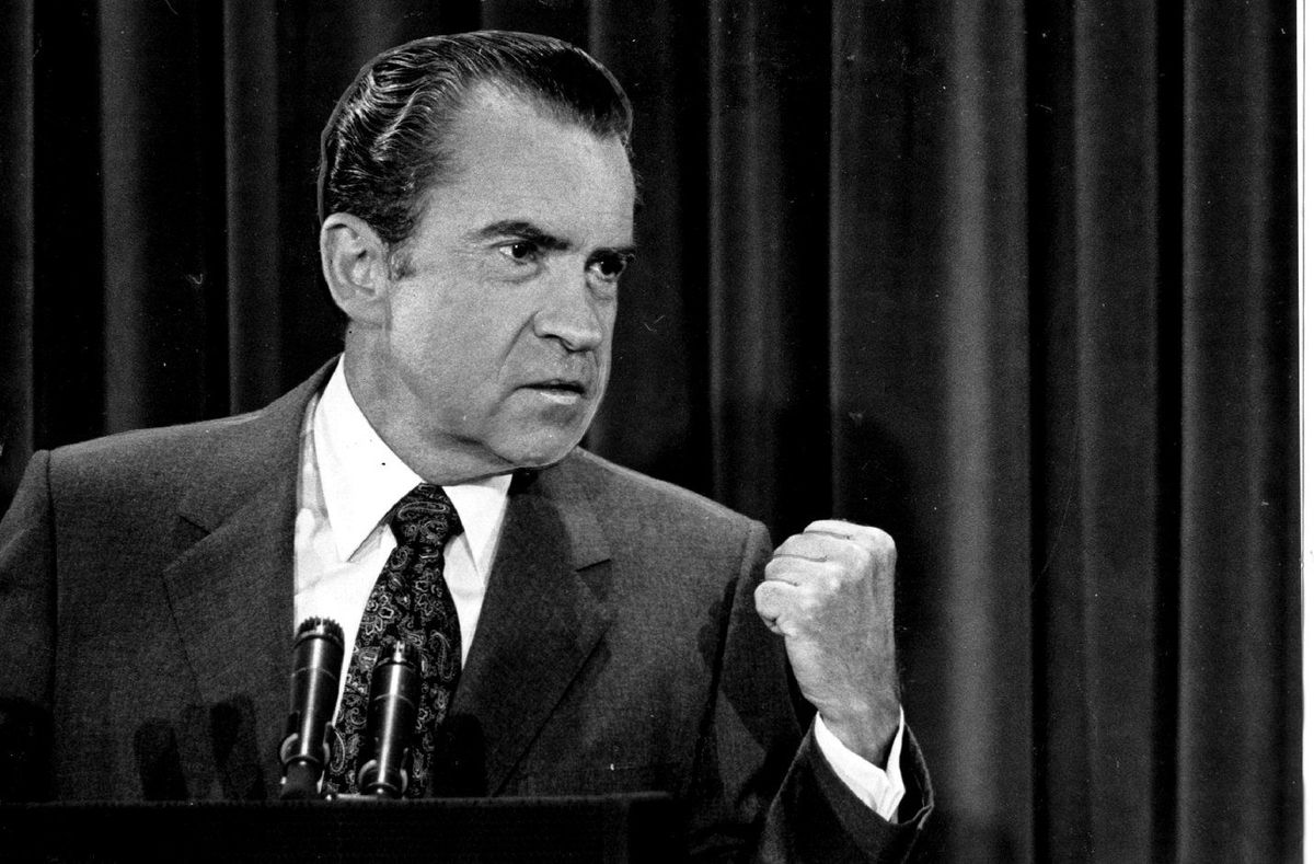 Richard Nixon making a fist during a press conference.
