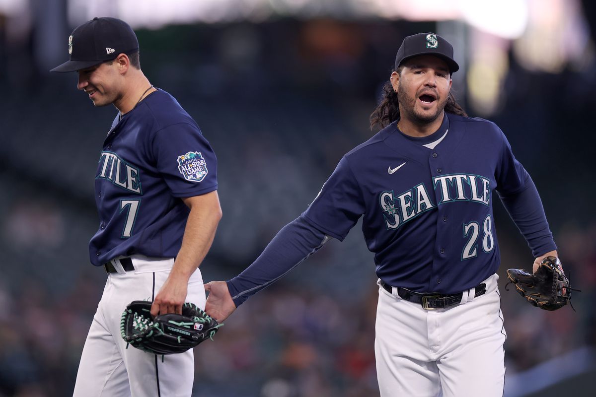 Marco Gonzales #7 and Eugenio Suarez #28 of the Seattle Mariners celebrate an out during the fifth inning against the Milwaukee Brewers at T-Mobile Park on April 19, 2023