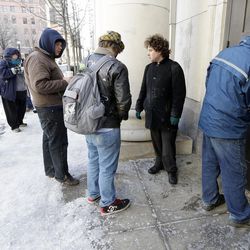In this Feb. 19, 2015 photo, people wait to enter the Nashville Public Library as Rick Reed, right, the library's superintendent of plant operations and maintenance, unlocks the front doors in Nashville, Tenn. Many public libraries discourage homeless people from hanging around. But more and more libraries are beginning to view services to the homeless as an important part of their mission. 