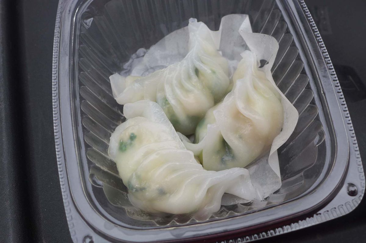 Four pale frilled dumplings in a clear plastic container.