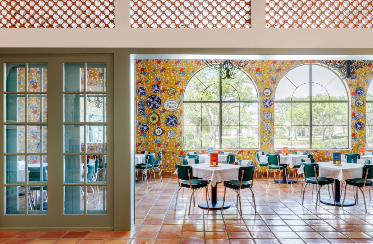 Los Tios’ dining room interior with patterned tile walls and tables draped in white tablecloths.