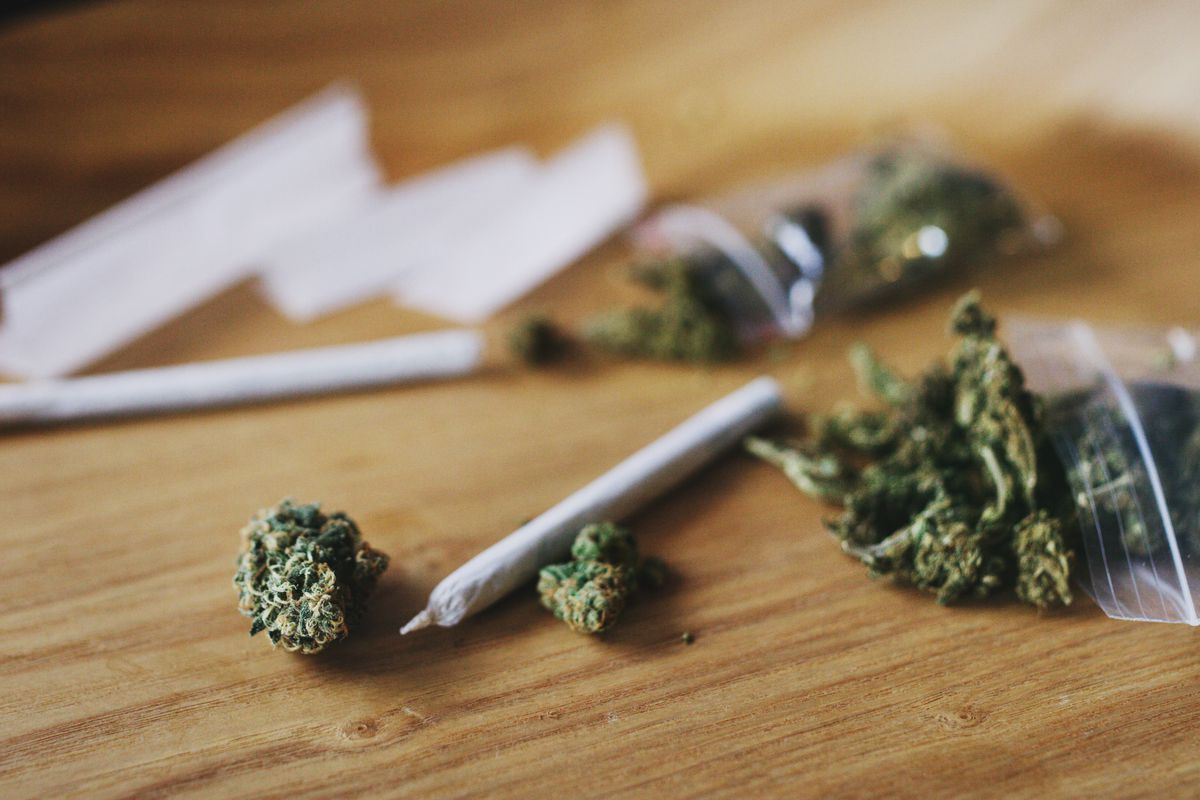 Cannabis and a rolled joint lie on a table.