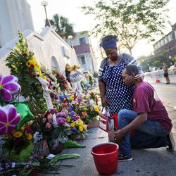 FILE - In this June 20, 2015 file photo, Allen Sanders, right, kneels next to his wife Georgette, both of McClellanville, S.C., as they pray at a sidewalk memorial in memory of the shooting victims in front of Emanuel AME Church in Charleston, S.C. Prosecutors who wanted to show that Dylann Roof was a cruel, angry racist simply used his own words at his death penalty trial on charges he killed nine black people in June 2015 at a Charleston church. Roof was convicted Thursday in the chilling attack on nine black church members who were shot to death last year during a Bible study, affirming the prosecution's portrayal of a young white man who hoped the slayings would start a race war or bring back segregation.