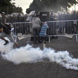 People run from tear gas fired by police as they protest outside the Minerao stadium where a Confederations Cup soccer match takes place between Japan and Mexico in Belo Horizonte, Brazil, Saturday, June 22, 2013. Demonstrators once again took to the streets of Brazil on Saturday, continuing a wave of protests that have shaken the nation and pushed the government to promise a crackdown on corruption and greater spending on social services. 
