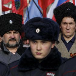 People dressed as Cossacks attend a rally just outside Moscow's Kremlin, Saturday, Feb. 21, 2015. Thousands of protesters have gathered in Moscow to demonstrate against what they call the "fascist coup" one year ago in neighbouring Ukraine. 