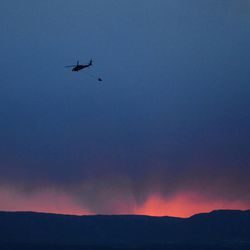 A helicopter makes another evening water run as the Black Forest Fire burns out of control for a second straight day near Colorado Springs on Wednesday, June 12, 2013. The fire has consumed 11,500 acres. It has destroyed 92 homes and damaged others. The erratic fire has forced the evacuation of thousands of people.  (AP Photo/BryanOller)