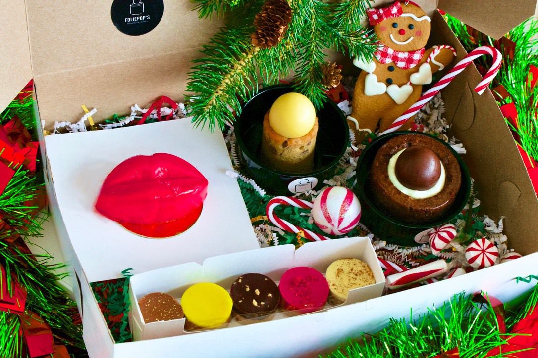 A Christmas box, which includes an original FoliePop, a mini FoliePop, five tartlets of various flavors, and a French kiss cake.