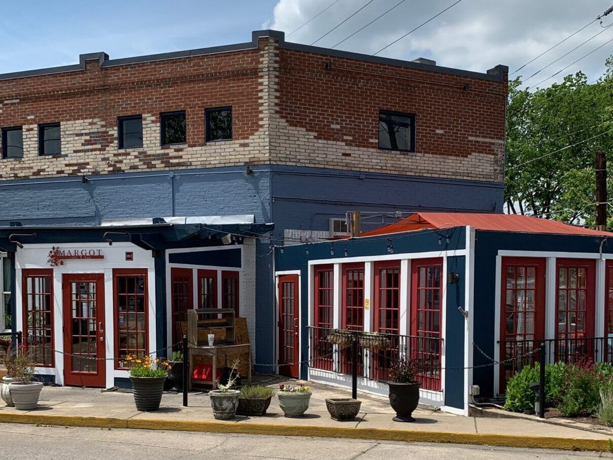 The front exterior of Margot Cafe and Bar in East Nashville, with some bare brick walls and some painted brick walls.