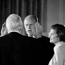 Gerald R. Ford takes the oath of office as the 38th president of the United States as his wife, Betty, right, stands at his side in the East Room of the White House in Washington, D.C., Aug. 4. 1974. Administering the oath is Chief Justice of the United States Warren Burger. Ford was sworn in following the resignation of Richard M. Nixon as chief executive.