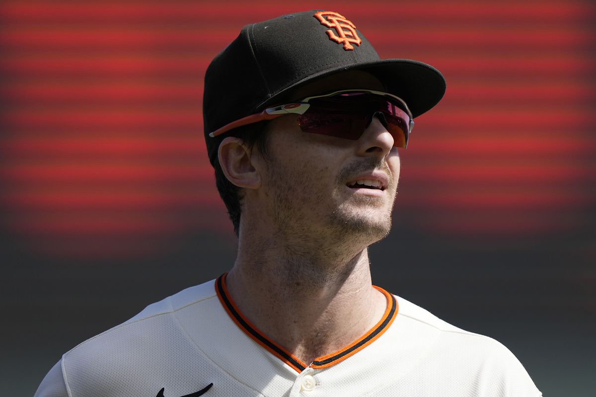Mike Yastrzemski looking up while wearing a hat and sunglasses