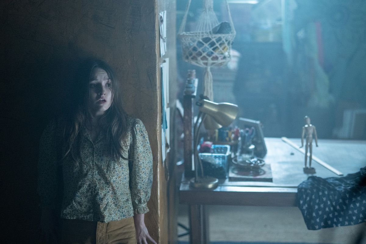 Kaitlyn Dever as Brynn Adams hides from a wooden joint doll in No One Will Save You