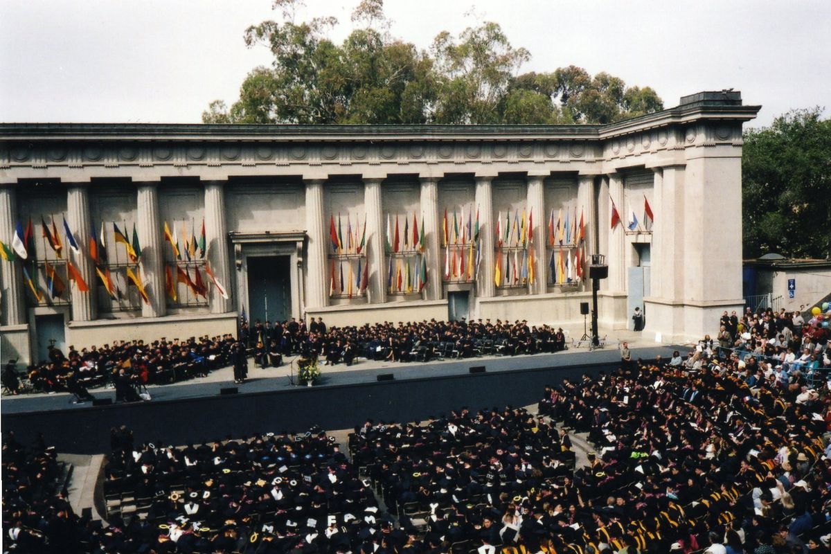 Crowds of graduates in black caps and gowns at the Greek theater at UC Berkeley. 