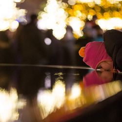 A girl sticks her face in the fountain as people tour the Christmas lights near Temple Square in Salt Lake City on Friday, Nov. 25, 2016.