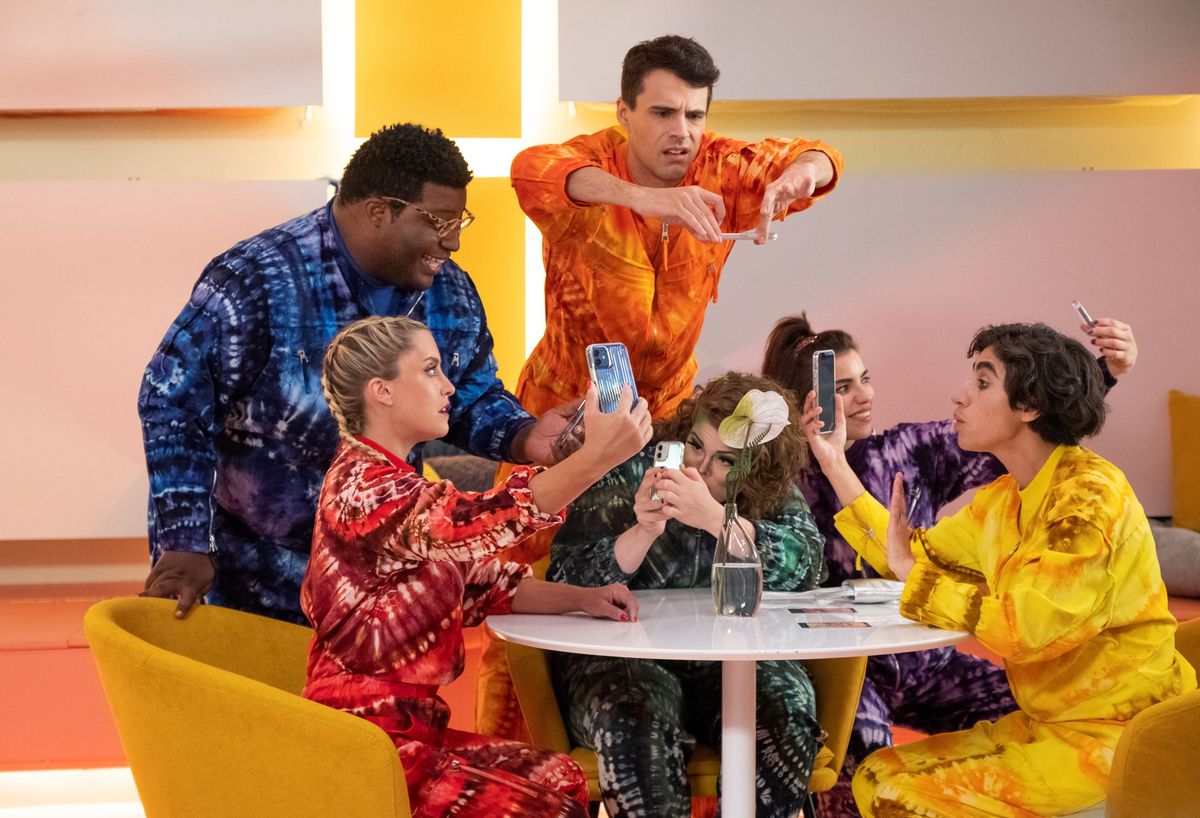 Los influencers del culto de Dory se sientan alrededor de una mesa con monos de colores brillantes en la temporada 5 de Search Party