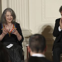 The recipients of the 2016 Kennedy Center Honors, Argentine pianist Martha Argerich, left, with actor Al Pacino, makes a gesture as she is recognized during a reception in their honor in the East Room of the White House in Washington, Sunday, Dec. 4, 2016, hosted by President Barack Obama and first lady Michelle Obama. 