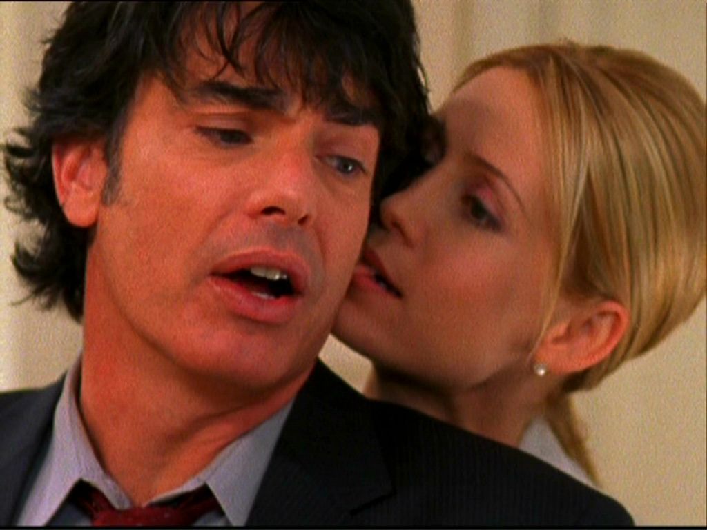 Kirsten Cohen (Kelly Rowan) romantically biting Sandy Cohen’s (Peter Gallagher) ear on The OC