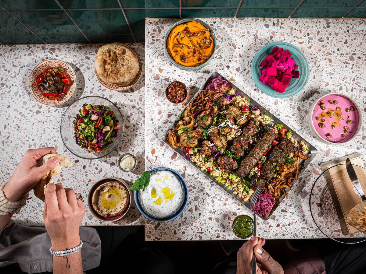 Dips, kebabs, and more on a patterned table.