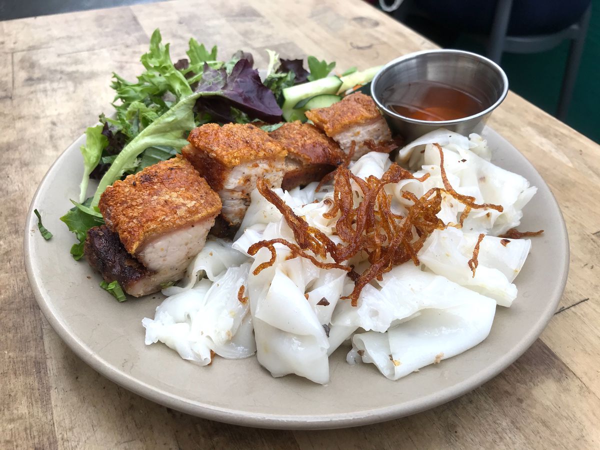 A plate of crispy roasted pork with rice noodles