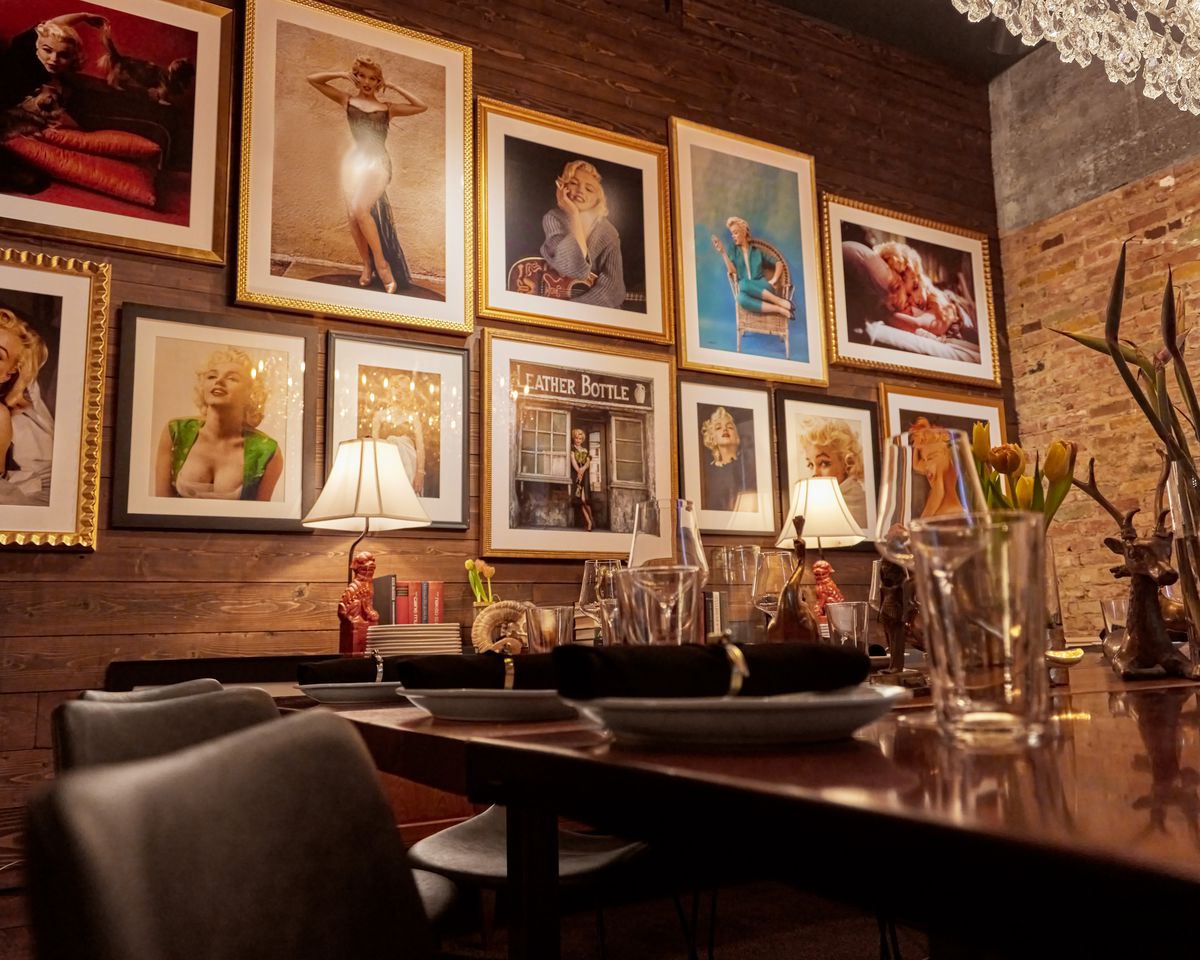 A gallery of Marilyn Monroe photographs are displayed above a dining table.