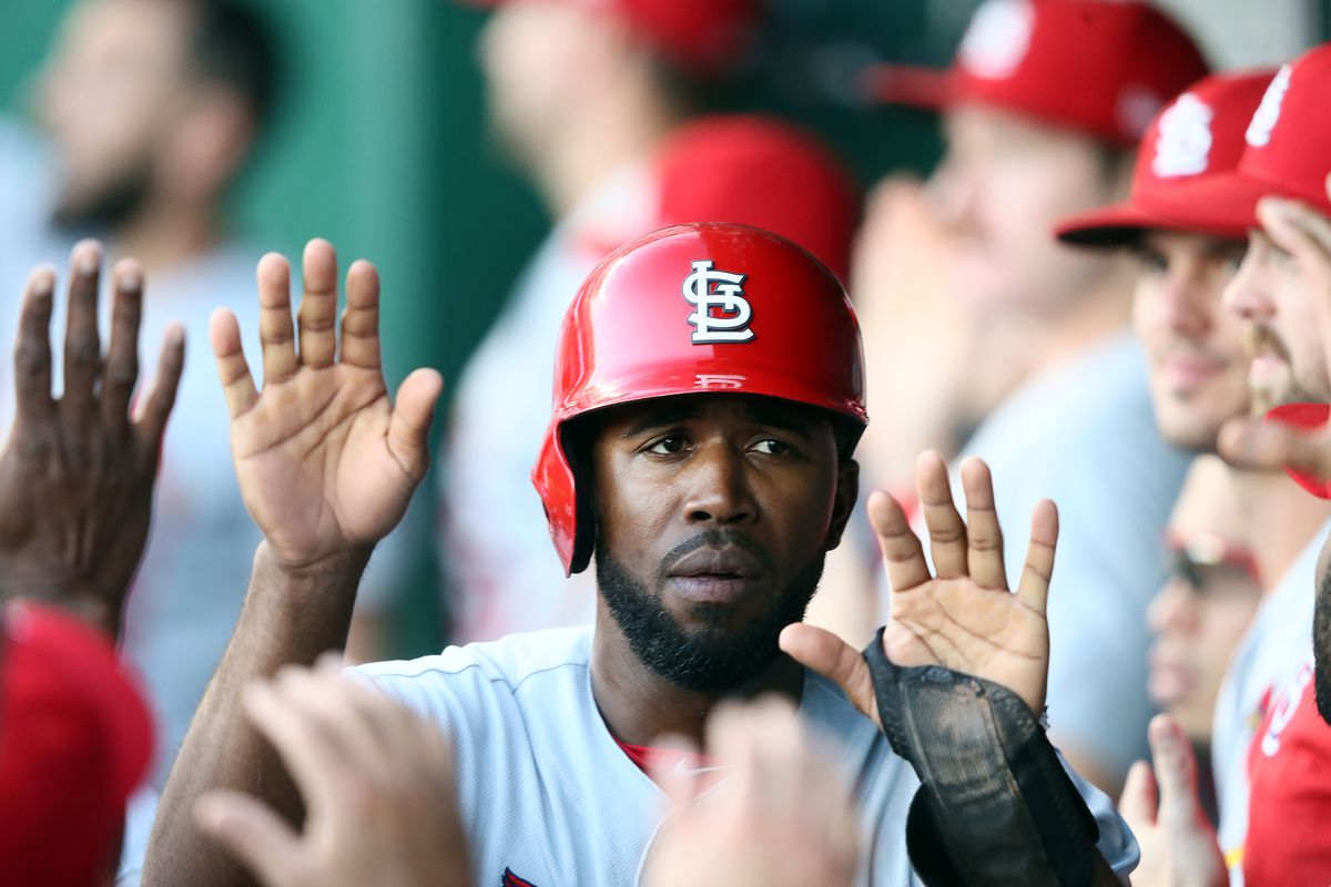  Dexter Fowler #25 of the St. Louis Cardinals is congratulated by teammates in the dugout after scoring during the 1st inning of the game against the Kansas City Royals at Kauffman Stadium on August 13, 2019 in Kansas City, Missouri.