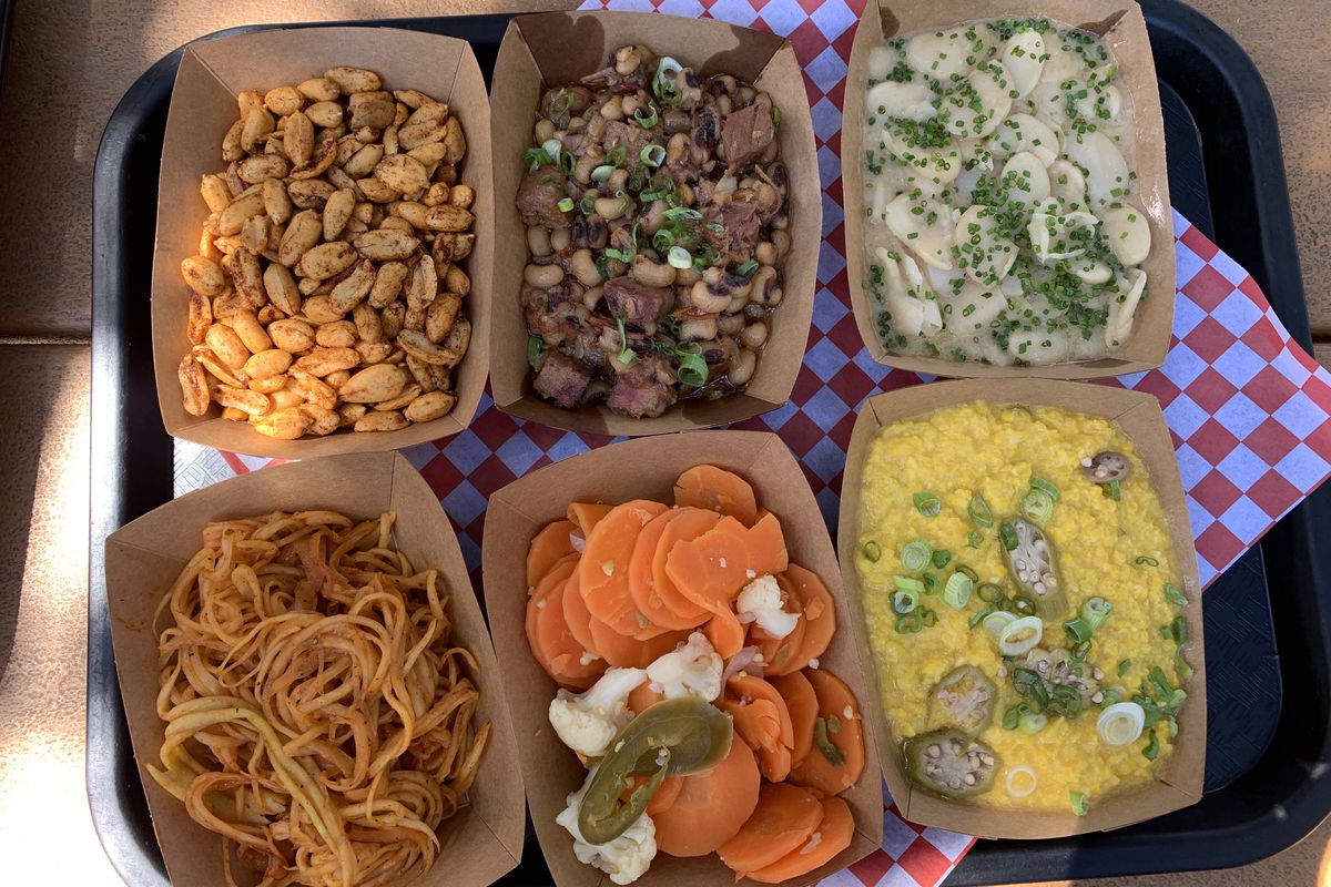 Six dishes in brown cardboard boxes, including nuts, beans, pickled vegetables, and more.