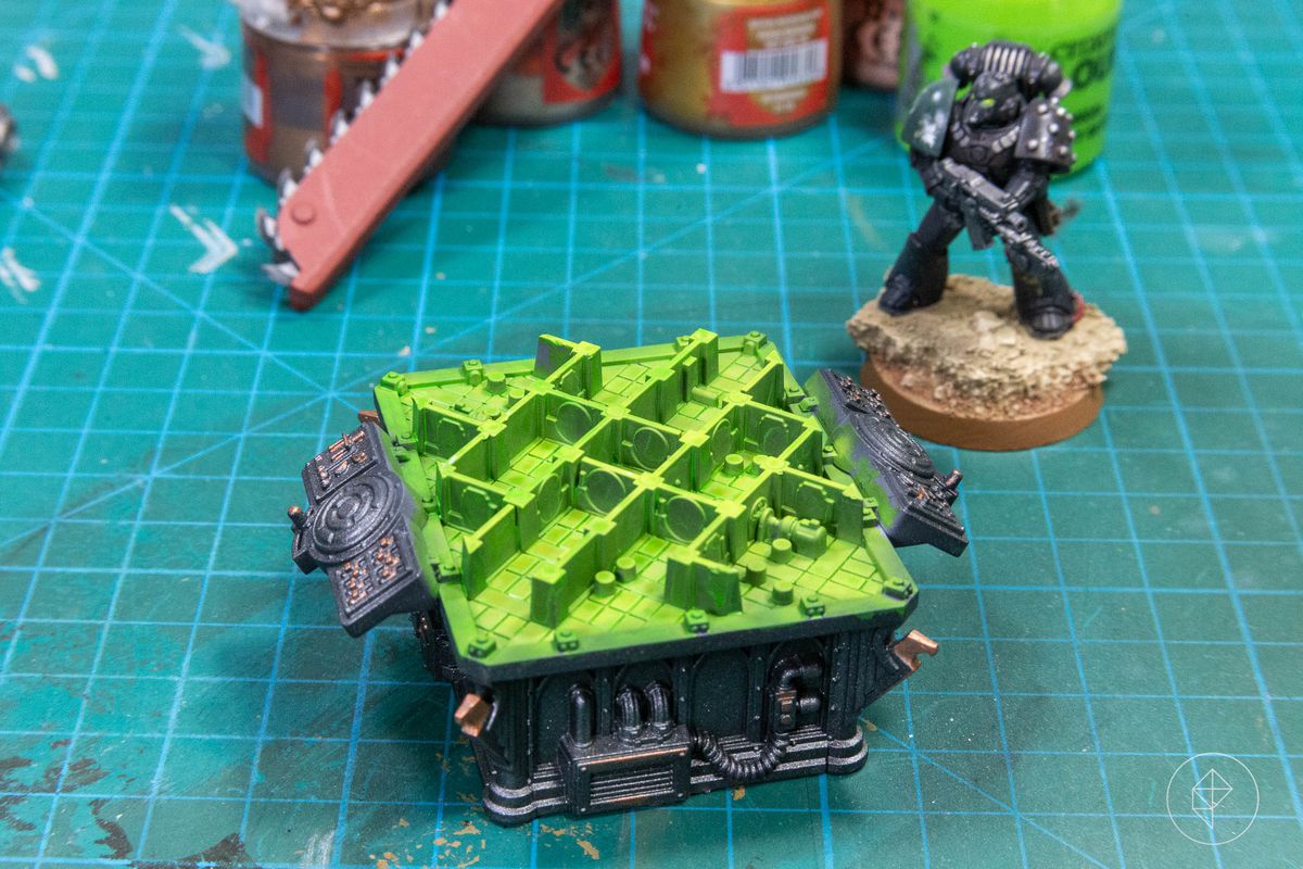 A close-up of a tiny game board from inside the latest 40k Kill Team boxed set, Soulshackle. A miniature looks on.